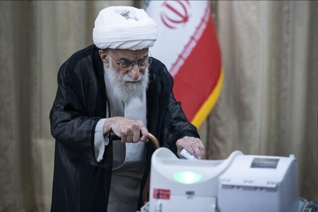 تصویری جالب از احمد جنتی پای دستگاه الکترونیک رای‌گیری