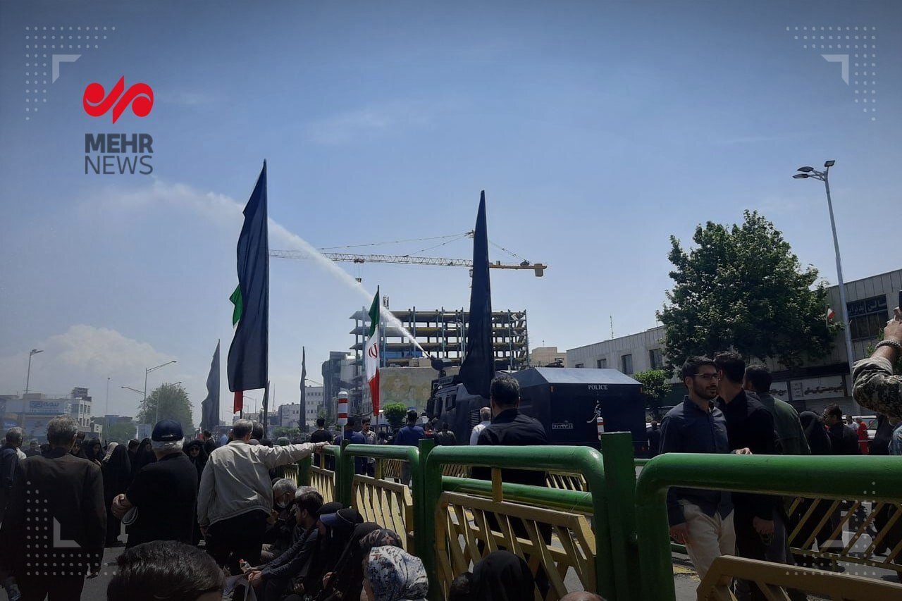 خنک شدن مردم توسط ماشین آب‌پاش یگان ویژه پلیس | تصویر